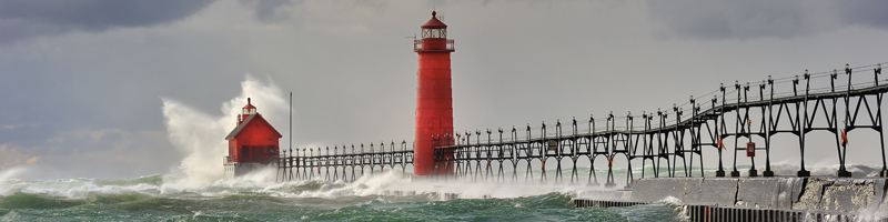 Foto: roter Leuchtturm und rotes Haus inmitten stürmischer See